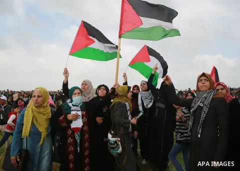 Palestinian women wave Palestinian flags during a tent city protest along the Israel border with Gaza, demanding the right to return to their homeland, east of Gaza City March 30, 2018. Photo by Mohammed Dahman