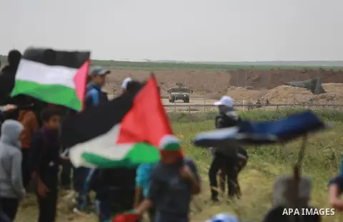 Palestinians take part during a tent city protest as Israeli military vehicle is seen on (background) at along the Israel border with Gaza, demanding the right to return to their homeland, east of Gaza City March 30, 201...