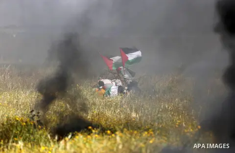 Palestinian protesters take cover during clashes with Israeli security forces in a tent city protest along the Israel border with Gaza, demanding the right to return to their homeland, in Khan Younis in the southern Gaza...