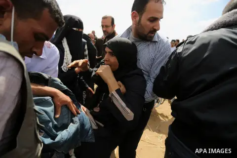 A wounded Palestinian woman is evacuated during clashes with Israeli security forces during a tent city protest along the Israel border with Gaza, demanding the right to return to their homeland, in Khan Younis in the so...