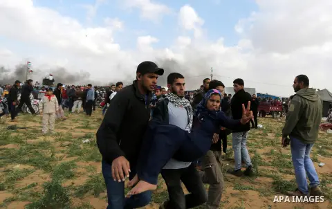 A wounded Palestinian woman is evacuated during clashes with Israeli security forces during a tent city protest along the Israel border with Gaza, demanding the right to return to their homeland, in Khan Younis in the so...