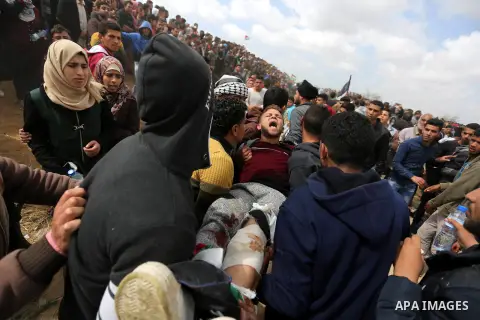 A wounded Palestinian is evacuated during clashes with Israeli security forces during a tent city protest along the Israel border with Gaza, demanding the right to return to their homeland, in Khan Younis in the southern...