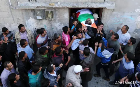 Palestinian mourners carry the body of Faris al-Raqib, who died from his injuries after being shot in the stomach by Israeli forces a few days earlier, in Khan Yunis, during his funeral in the southern Gaza Strip on Apri...