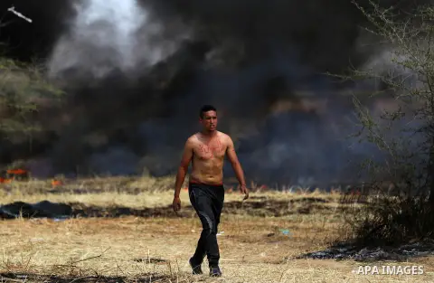 Palestinian protesters demonstrate during clashes with Israeli security forces in a protest, at the Israel-Gaza border during a tent city protest at the Israel-Gaza border, in Khan Yunis in the southern Gaza Strip, on Ap...