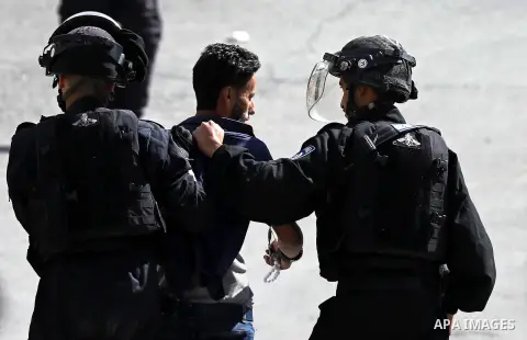 Israeli security forces detian a Palestinian man as they protect Jewish settlers during visit the tomb of Othniel Ben Kenaz in the West Bank city of Hebron on April 2, 2018. Photo by Wisam Hashlamoun
