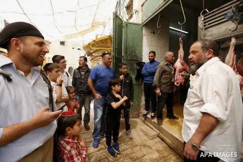 A Jewish settler looks at meat at a Palestinian butcher's shop in Hebron, in the occupied West Bank April 3, 2018. Photo by Wisam Hashlamoun