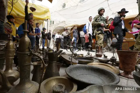 Jewish settlers gather at a Palestinian market in Hebron, in the occupied West Bank April 3, 2018. Photo by Wisam Hashlamoun