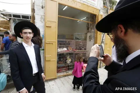 Jewish settlers gather at a Palestinian market in Hebron, in the occupied West Bank April 3, 2018. Photo by Wisam Hashlamoun