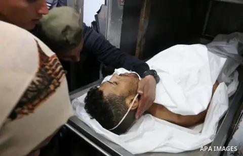 Relatives of Palestinian Ahmed Arafa, 25, who was killed by Israeli security forces during clashes along Israel border with Gaza, mourn over his body in morgue at a hospital in the central Gaza Strip April 3, 2018. Photo...