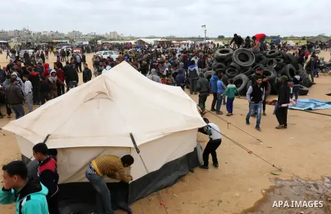 Palestinian protesters collect tires during a tent city protest along the Israel border with Gaza, demanding the right to return to their homeland, in Khan Yunis in the southern Gaza Strip April 3, 2018. Photo by Ashraf...