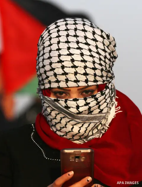 A masked Palestinian woman with Palestinian traditional checkered keffiyeh takes part during a tent city protest along the Israel border with Gaza, demanding the right to return to their homeland, in east of Gaza city on...