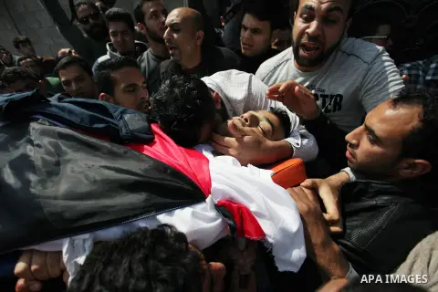 Mourners and journalists carry the body of Palestinian journalist Yasser Murtaja, 30, who died from his injuries after he was shot by Israeli security forces during clashes at the Israel-Gaza border on Friday, during his...