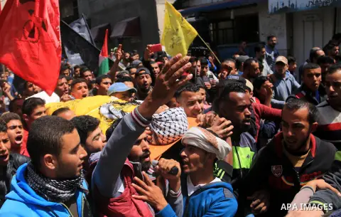 Palestinian mourners carry the body of Ibrahim el-Aar, 18, who who died the day before during clashes with Isareli security forces at the Israel-Gaza border, during his funeral at al-Nusairat refugee camp in the central...