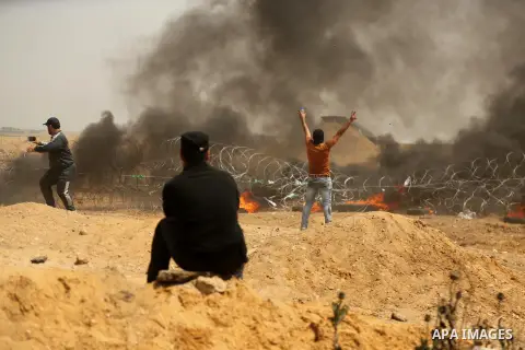 Palestinian gather during clashes with Israeli security froces in a tent city protest where Palestinians demand the right to return to their homeland, at the Israel-Gaza border, east of Gaza city, on April 13, 2018. Phot...