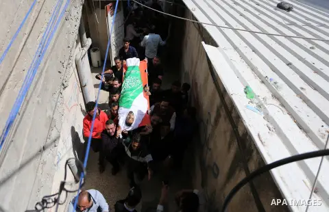 Mourners carry the body of Palestinian Islam Herzallah, 28, who was killed during clashes with Israeli security forces at the Israel-Gaza border during his funeral in Gaza City on April 14, 2018. Photo by Ashraf Amra