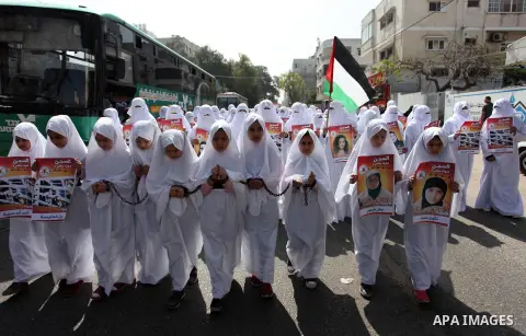 Palestinian girls wearing white shroud as they take part in a demonstration in support of Palestinian prisoners held in Israeli jails, in Gaza City, on April 16, 2018. Photo by Mahmoud Ajour