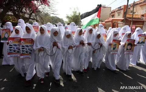 Palestinian girls wearing white shroud as they take part in a demonstration in support of Palestinian prisoners held in Israeli jails, in Gaza City, on April 16, 2018. Photo by Mahmoud Ajour