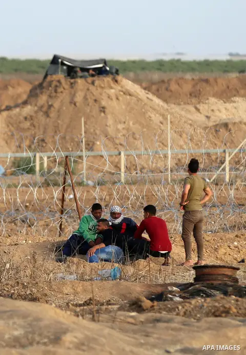 Palestinians gather during clashes with Israeli security forces in a tent city protest along Israel border with Gaza, demanding to return to their homeland, east of Gaza City, April 18, 2018. Photo by Yasser Qudih