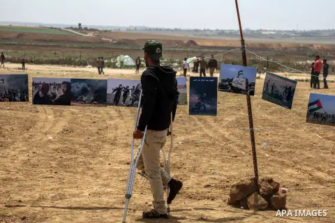 A Palestinian protester watches hanging pictures during protest tents at the Israel-Gaza border where Palestinians demand the right to return to their homeland, in Jabalia in the northern Gaza Strip April 20, 2018. Photo...