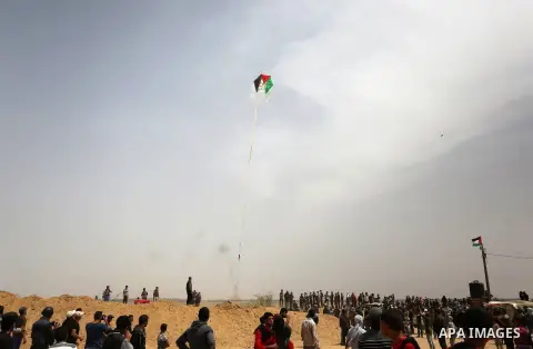 Palestinian protesters attempt to fly a kite laden with a molotov cocktail over the border with Israel before cutting the string across the fence, during clashes with Israeli security forces at tents protest where Palest...
