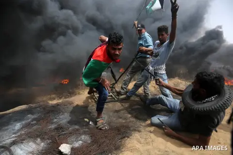 Palestinian protesters use a larag slingshot to hrul stones during clashes with Israeli security forces at tents protest at the Israel-Gaza border where Palestinians demand the right to return to their homeland, in Khan...