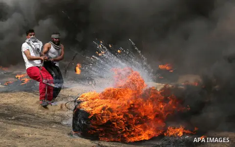 Palestinians burn tires during clashes with Israeli security forces at tents protest at the Israel-Gaza border where Palestinians demand the right to return to their homeland, in Khan Younis in the southern Gaza Strip on...