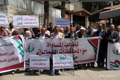 Palestinian Authority employees in the Gaza Strip take part in a protest demanding their salaries in front of the headquarters of the Council of Ministers, in Gaza city on April 24, 2018. Photo by Mahmoud Ajour