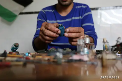 Palestinian artist Magdy Abu Takeya, 38, converts gunshots used by the Israeli security forces against Palestinian protesters to small pieces of art knows as "Art of thumbnails" at his house in Nuseirat in the central Ga...