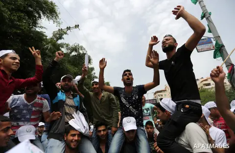Palestinian labors chant slogans during a protest against the continued Israeli siege and the spread of unemployment to mark the International Labor Day, in front of the headquarters of the Council of Ministers, in Gaza...