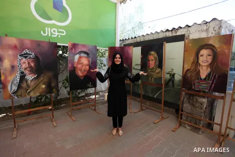 A Palestinian artisit, Ola Al Sharif ,22, displays her drawings in an exhibition, in Gaza city on May 9, 2018. Photo by Mahmoud Ajour