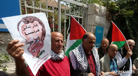Palestinians hold caricature posters depicting French President Emmanuel Macron during a protest in front of French Institute aganist participation of French Institute in Paris on the 70th anniversary of the establishmen...