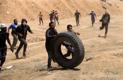 Palestinian protesters gather during clashes with Israeli security froces in a tent city protest where Palestinians demand the right to return to their homeland, on the occasion of the 70th anniversary of the "Nakba", an...