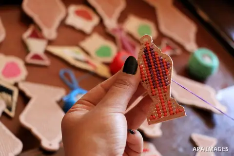 A Palestinian girl Nariman Abu Obaid, 21, uses strings to embroidery on wood as she manufactures traditional lanterns known in Arabic as "Fanous" on the holy month of Ramadan in Deir Al Balah in the center of Gaza Strip,...