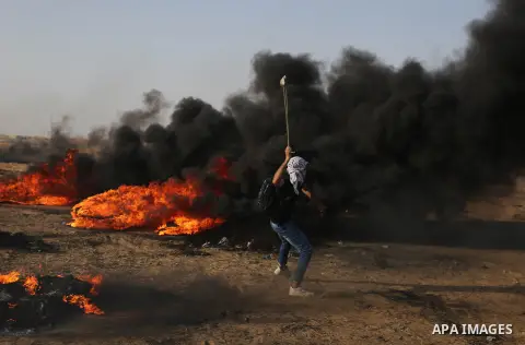 Palestinian protesters gather during clashes with Israeli security froces in a tent city protest where Palestinians demand the right to return to their homeland and against U.S. embassy move to Jerusalem at the Israel-Ga...