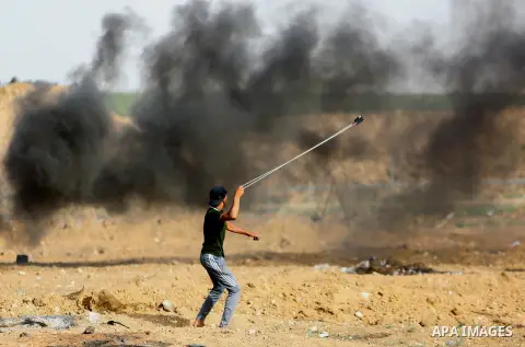 Palestinian protesters gather during clashes with Israeli security froces in a tent city protest where Palestinians demand the right to return to their homeland and against U.S. embassy move to Jerusalem at the Israel-Ga...