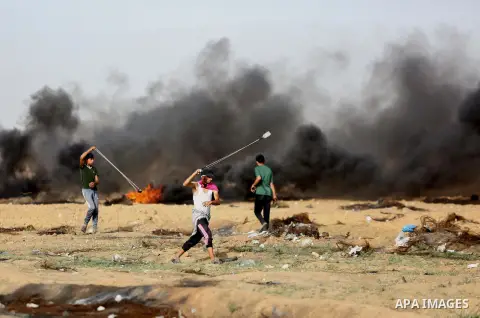 Palestinian protesters gather during clashes with Israeli security froces in a tent city protest where Palestinians demand the right to return to their homeland and against U.S. embassy move to Jerusalem at the Israel-Ga...