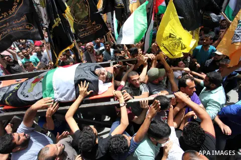 Palestinian mourners carry the body of Hussein Abu Aweida, 41, who died of his wounds endured during clashes with Israeli troops in a tent city protest where Palestinians demand the right to return to their homeland at t...