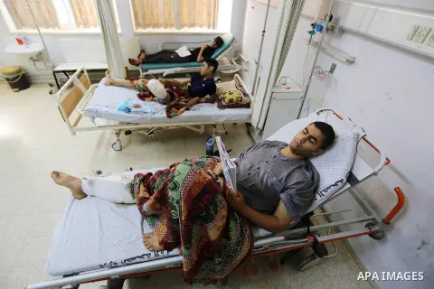 Palestinian youths who were wounded during during clashes with Israeli troops in tents protest demanding the right to return to their homeland, at the Israel-Gaza border, lay on beds as they prepare themselves to sit for...