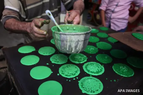 A Palestinian vendor prepares "Qatayef", traditional pancakes that are popular at a market during the holy month of Ramadan in Gaza city of June 1, 2018. Ramadan is sacred to Muslims because it is during that month that...