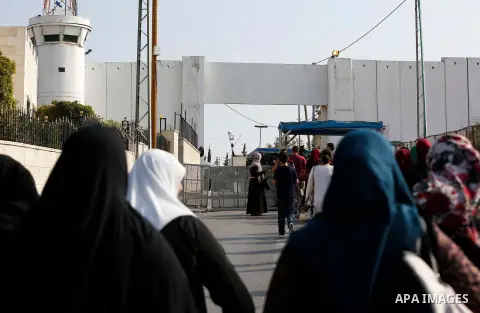 Palestinians make their way through an Israeli checkpoint along Israel's controversial separation barrier to attend the third Friday prayer of the holy fasting month of Ramadan in Jerusalem's Al-Aqsa mosque, in Bethlehem...