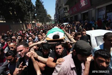 Palestinian mourners carry the body of Mohammed Hamada, 30, who died of his wounds endured during clashes with Israeli troops in a tent city protest where Palestinians demand the right to return to their homeland at the...