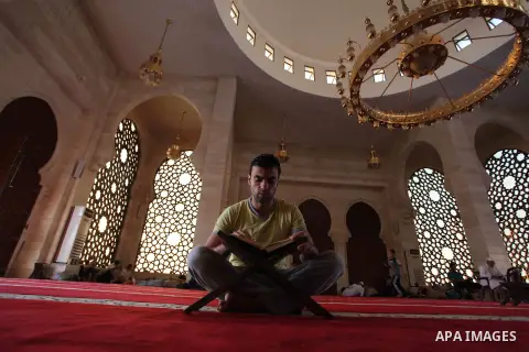 A Palestinian man reads the Koran, Islam's holiest book, at a mosque in Gaza City during the Muslim holy month of Ramadan, on June 6, 2018. Ramadan is sacred to Muslims because it is during that month that tradition says...