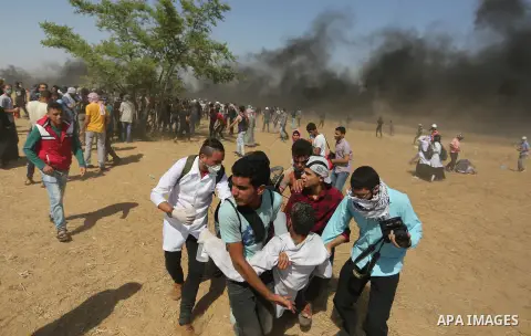A wounded Palestinian Medic is evacuated during clashes with Israeli security froces in a protest marking al-Quds Day, (Jerusalem Day), at the Israel-Gaza border in Khan Younis in the southern Gaza Strip on June 8, 2018....