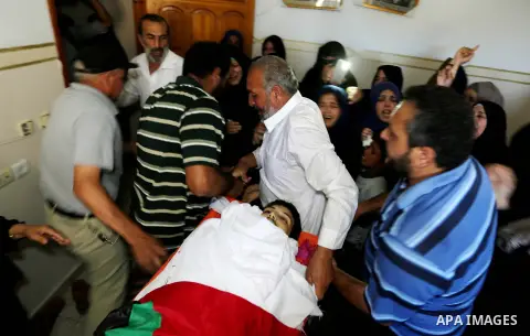 Palestinian relatives mourn over the body of Ziad al-Barim, 25, who was shot dead by Israeli troops during clashes at Israel-Gaza border, during his funeral in Khan Younis in the southern Gaza strip on June 9, 2018. Four...