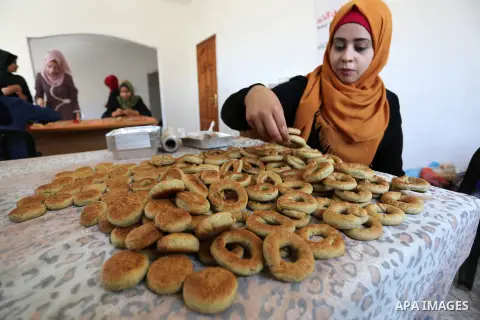 Palestinian women prepare traditional date-filled mini cakes to sell for customers a few days ahead of Eid al-Fitr holiday in Dair Al Balah, in the center of Gaza Strip on June 12, 2018. Eid al-Fitr marks the end of Musl...