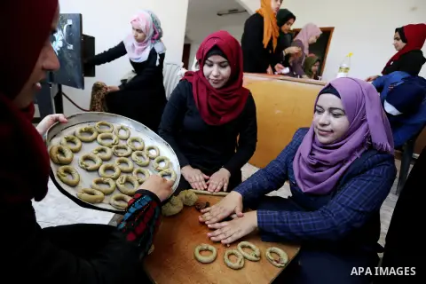 Palestinian women prepare traditional date-filled mini cakes to sell for customers a few days ahead of Eid al-Fitr holiday in Dair Al Balah, in the center of Gaza Strip on June 12, 2018. Eid al-Fitr marks the end of Musl...