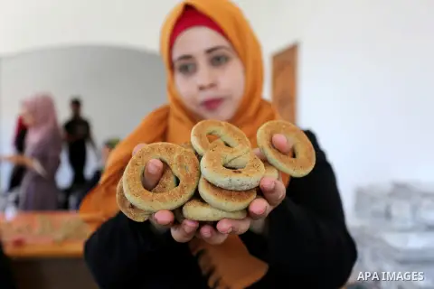 Palestinian women prepare traditional date-filled mini cakes to sell for customers a few days ahead of Eid al-Fitr holiday in Dair Al Balah, in the center of Gaza Strip on June 12, 2018. Eid al-Fitr marks the end of Musl...