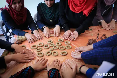 Palestinian women prepare traditional date-filled mini cakes to sell for customers a few days ahead of Eid al-Fitr holiday in Dair Al Balah, in the center of Gaza Strip on June 12, 2018. Eid al-Fitr marks the end of Musl...