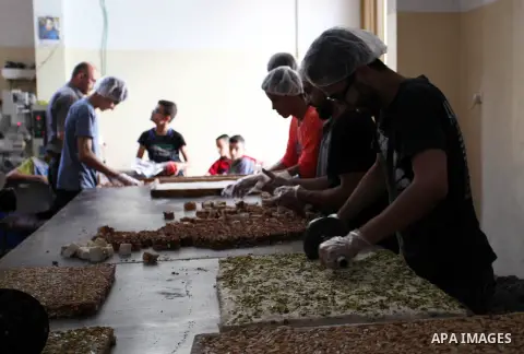 Palestinians prepare sweet known in Arabic as "Halkoum" in a store to be sold ahead of the Eid al-Fitr holiday in Gaza city on June 13, 2018. Eid al-Fitr marks the end of Muslim's holy fasting month of Ramadan when faith...