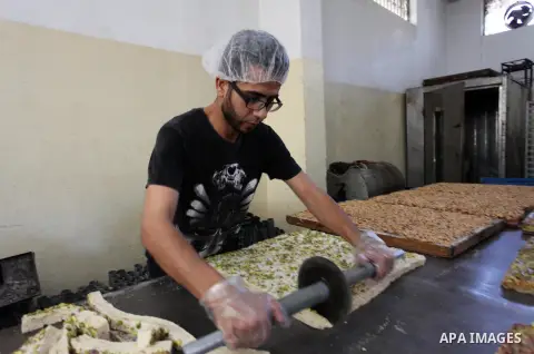 Palestinians prepare sweet known in Arabic as "Halkoum" in a store to be sold ahead of the Eid al-Fitr holiday in Gaza city on June 13, 2018. Eid al-Fitr marks the end of Muslim's holy fasting month of Ramadan when faith...